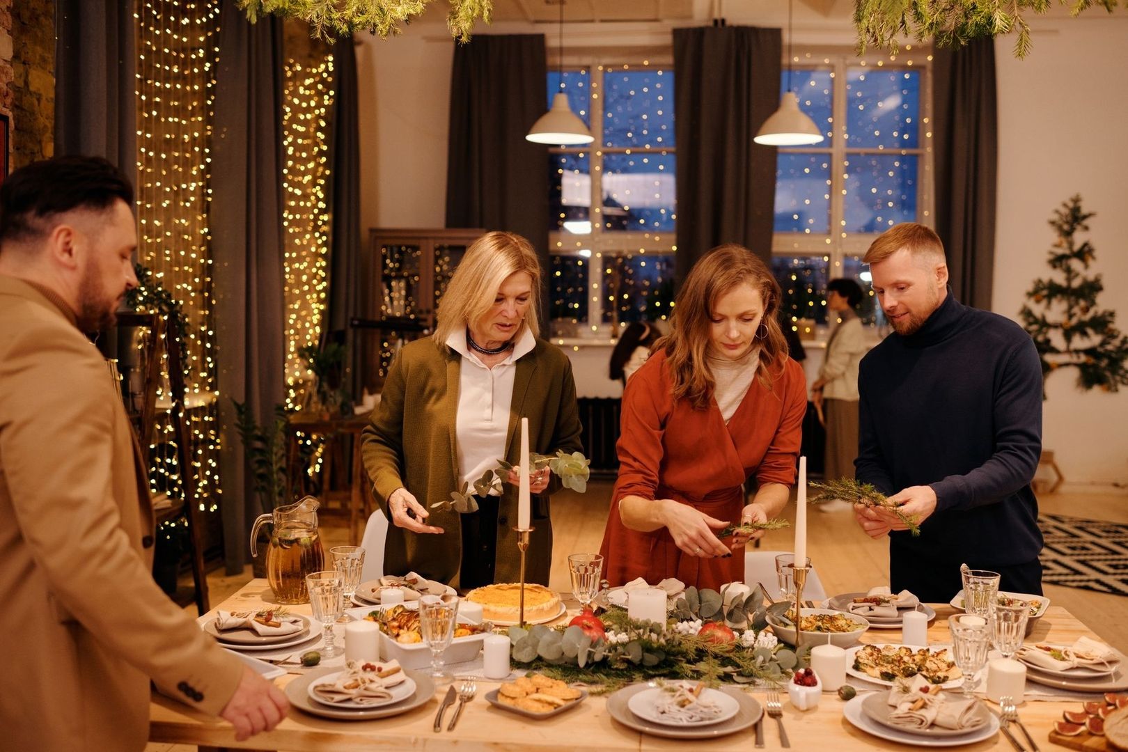 Gezelschap bereidt samen een feestelijk diner aan een gedekte tafel